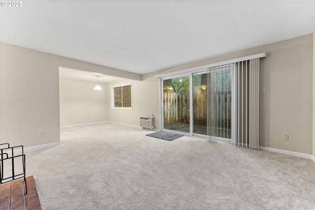 carpeted spare room featuring a wall mounted AC