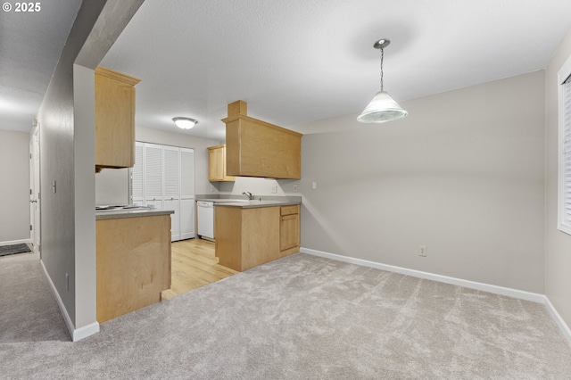 kitchen featuring dishwasher, sink, kitchen peninsula, light carpet, and light brown cabinetry