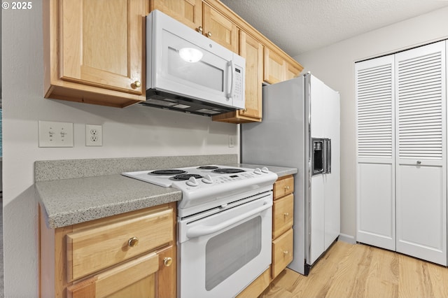 kitchen featuring light brown cabinets, white appliances, a textured ceiling, and light hardwood / wood-style flooring