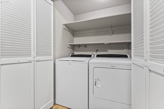 laundry area featuring separate washer and dryer and light hardwood / wood-style floors