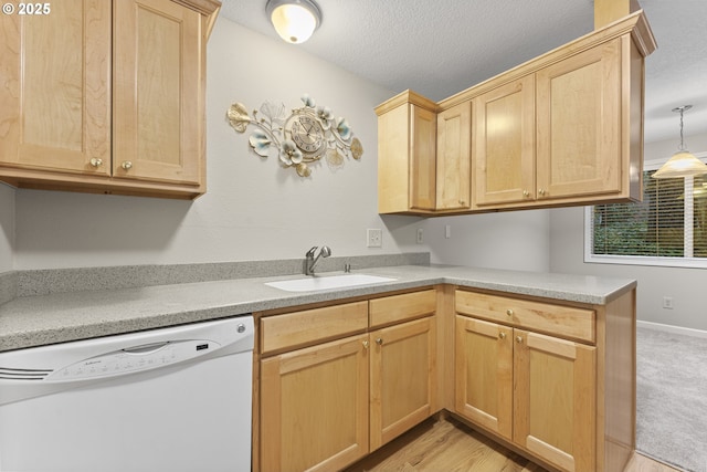 kitchen with light brown cabinetry, white dishwasher, hanging light fixtures, and sink