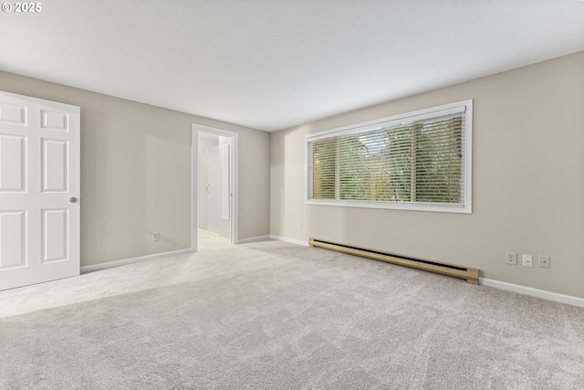 carpeted empty room with a baseboard heating unit