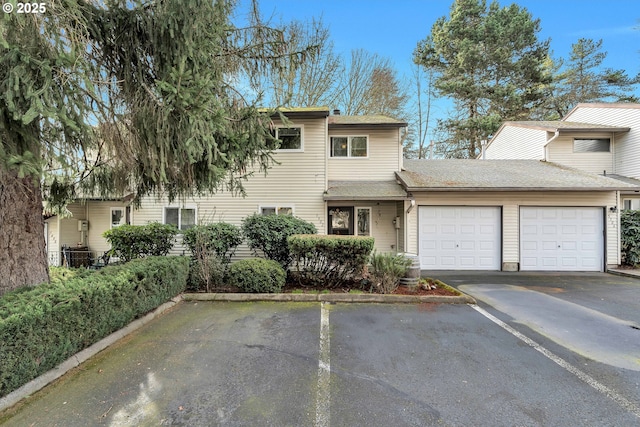 view of property with a garage and central air condition unit