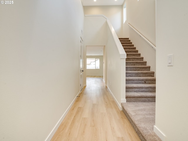 staircase with hardwood / wood-style flooring and a towering ceiling