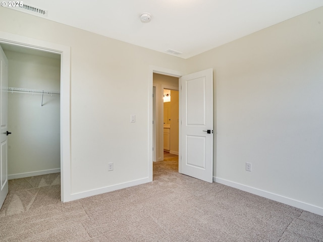 unfurnished bedroom featuring a closet and light carpet