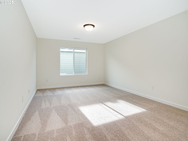 unfurnished room featuring light carpet