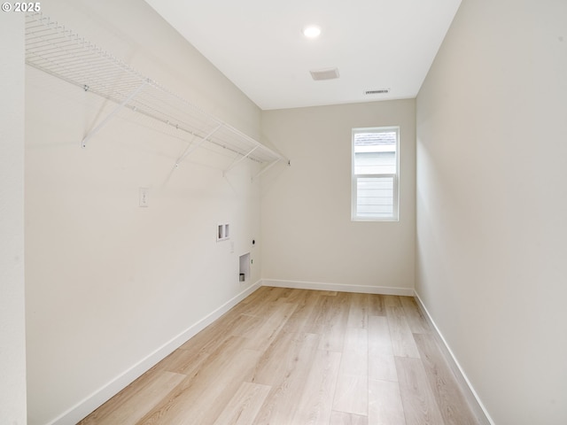 washroom with electric dryer hookup, hookup for a washing machine, and light hardwood / wood-style flooring