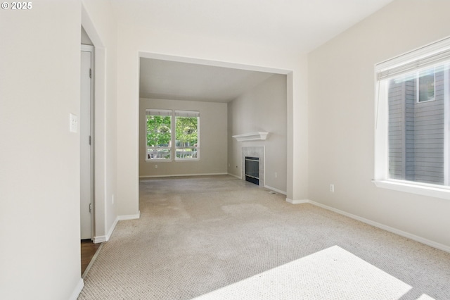 unfurnished living room featuring baseboards, carpet flooring, and a fireplace