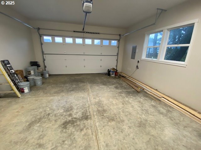 garage featuring electric panel and a garage door opener