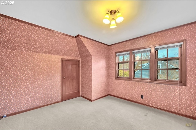 unfurnished room featuring wallpapered walls, crown molding, light colored carpet, and baseboards