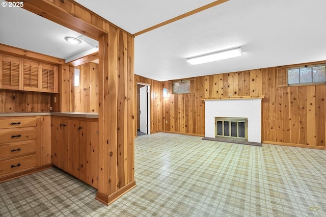 interior space with tile patterned floors, a fireplace, baseboards, and wood walls