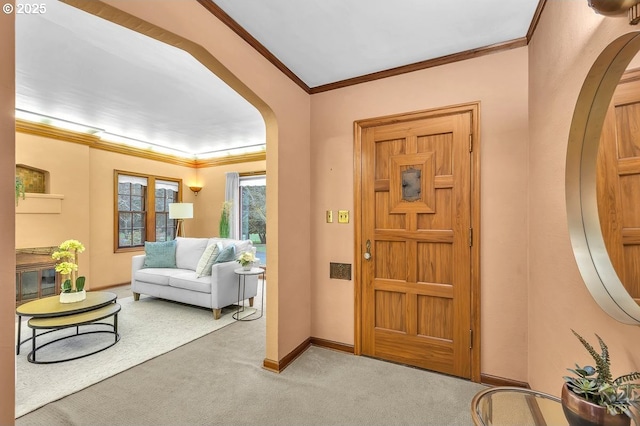 foyer entrance featuring arched walkways, baseboards, carpet, and ornamental molding