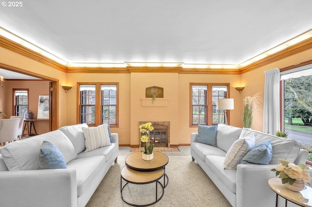 living room featuring crown molding, a healthy amount of sunlight, baseboards, and a high end fireplace