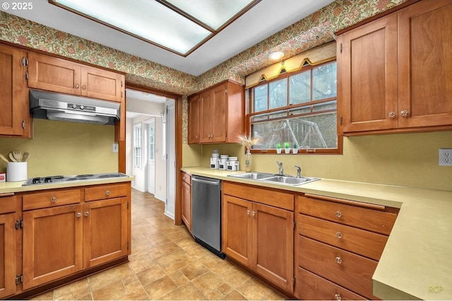 kitchen featuring a sink, cooktop, under cabinet range hood, dishwasher, and brown cabinets