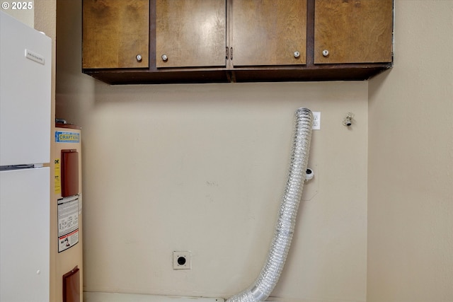 clothes washing area featuring cabinets and electric dryer hookup