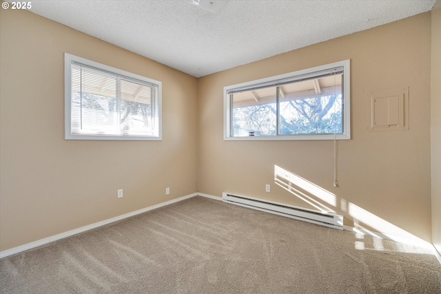 carpeted empty room featuring a baseboard radiator and a textured ceiling