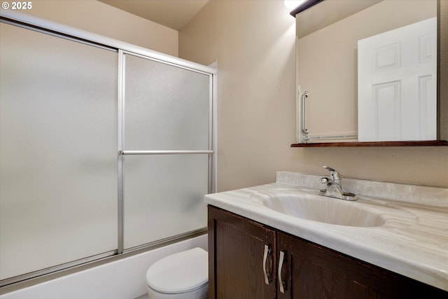 full bathroom with enclosed tub / shower combo, vanity, and toilet