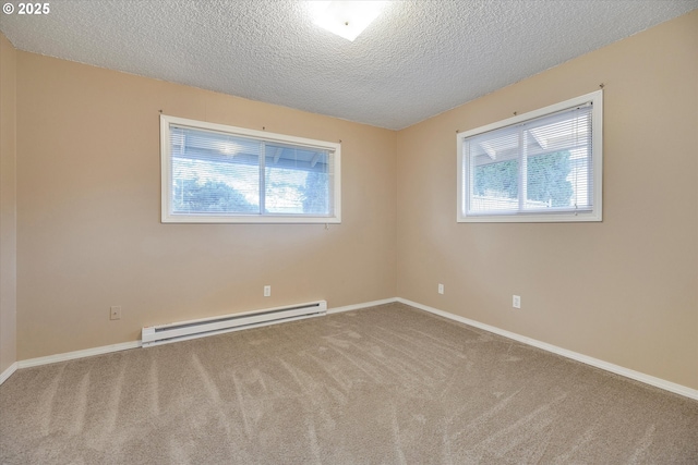 spare room with a healthy amount of sunlight, carpet flooring, a textured ceiling, and a baseboard heating unit