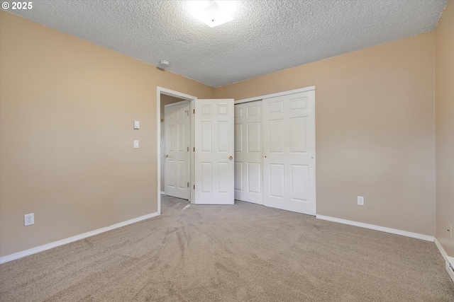 unfurnished bedroom with carpet floors, a textured ceiling, and a closet