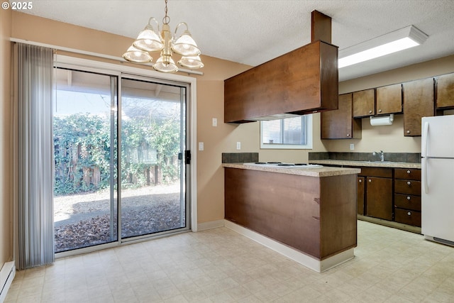 kitchen featuring decorative light fixtures, a baseboard radiator, sink, kitchen peninsula, and white appliances