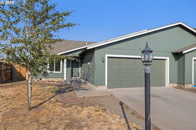 ranch-style home featuring concrete driveway and an attached garage