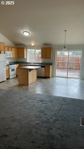 888 SE Kierra Pl, Madras, OR 97741 - kitchen with a breakfast bar, a center island, dark countertops, hanging light fixtures, and white appliances