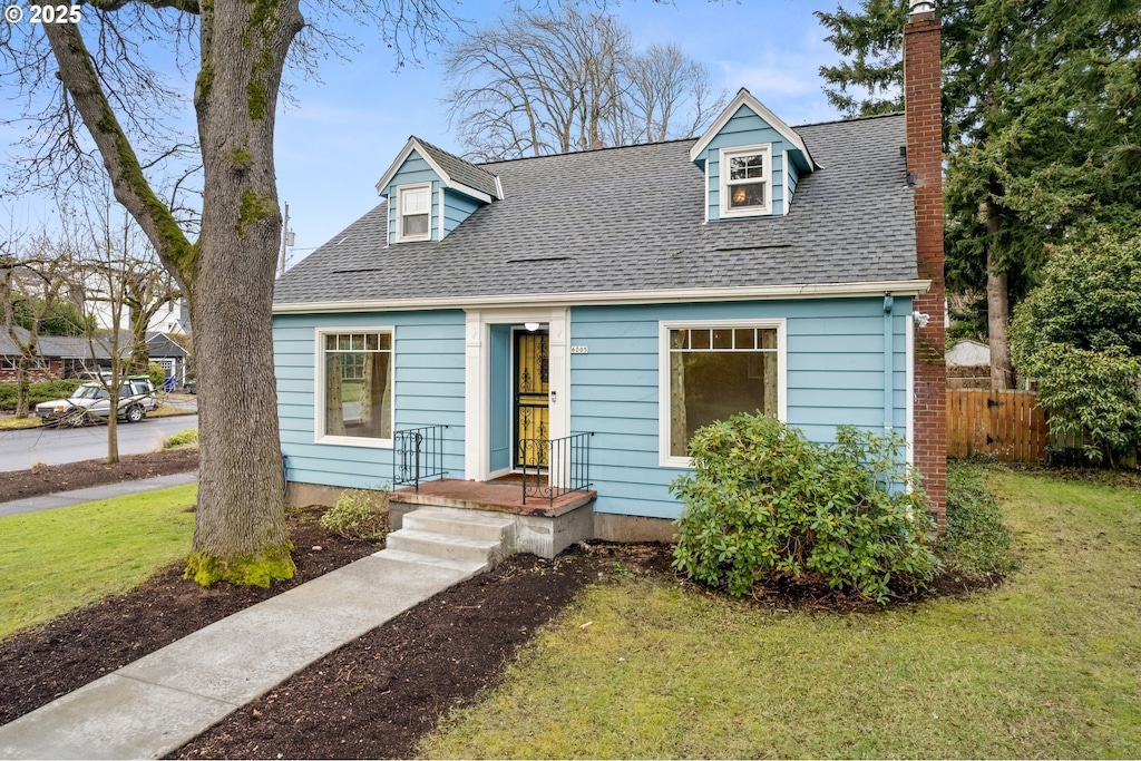 cape cod-style house with a front yard