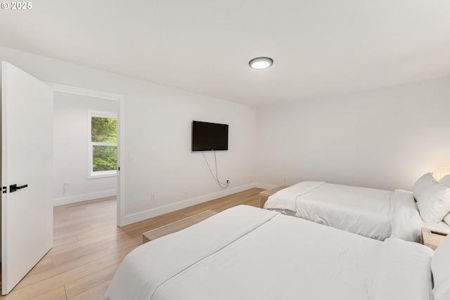 bedroom with baseboards and light wood finished floors