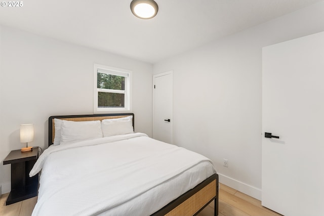 bedroom with baseboards and light wood finished floors