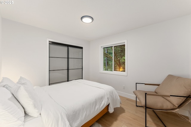 bedroom featuring baseboards and light wood finished floors