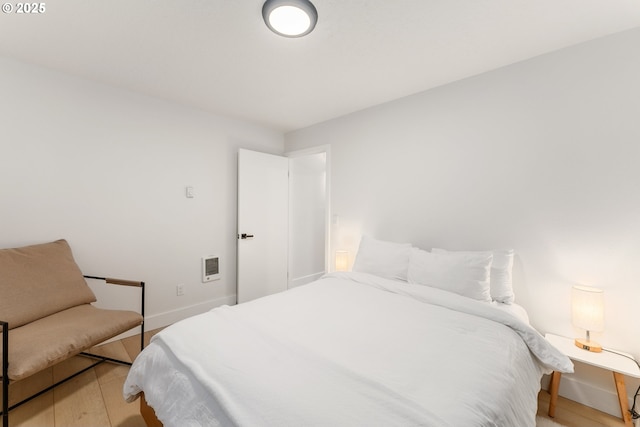 bedroom featuring light wood-style floors and baseboards