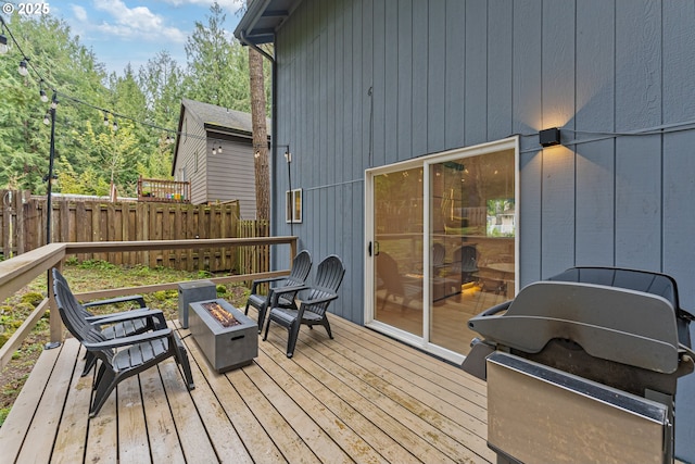 wooden deck featuring a fire pit and fence