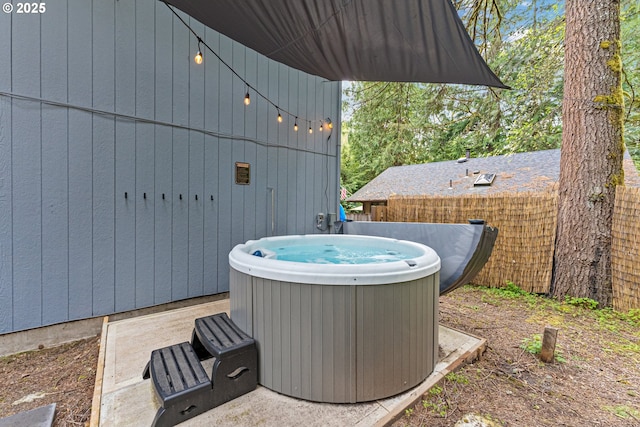 view of patio / terrace with a hot tub and fence