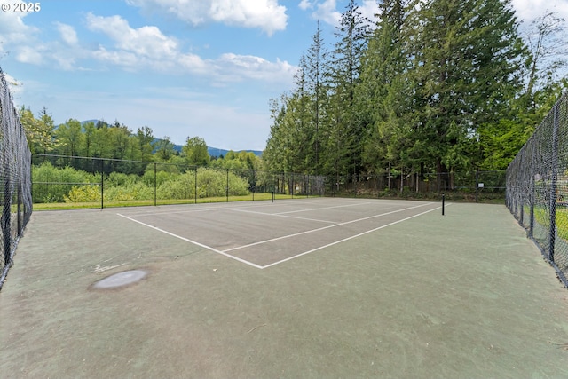 view of tennis court with fence and community basketball court