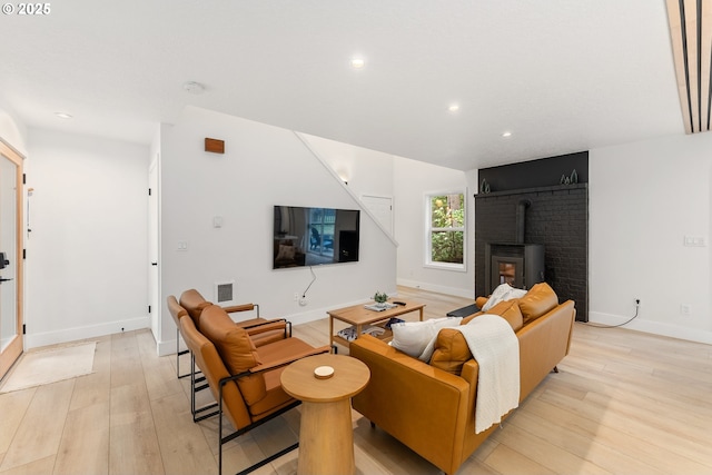 living room with recessed lighting, baseboards, and light wood finished floors