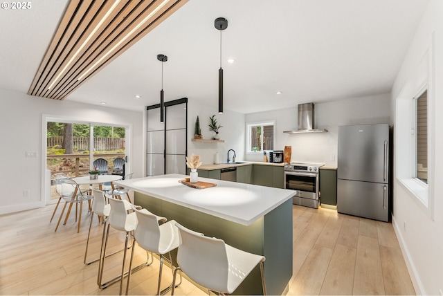 kitchen with open shelves, light wood finished floors, light countertops, wall chimney exhaust hood, and stainless steel appliances