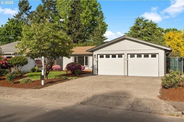 ranch-style home featuring concrete driveway, an attached garage, and fence