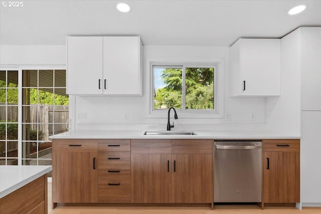 kitchen with dishwasher, a sink, light countertops, white cabinetry, and recessed lighting
