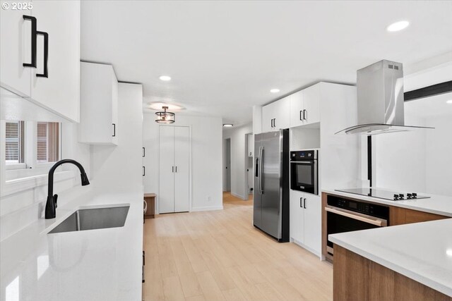 kitchen featuring stainless steel appliances, extractor fan, a sink, modern cabinets, and recessed lighting