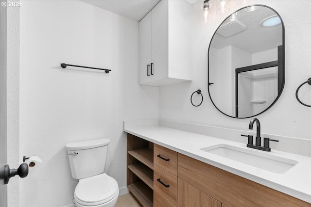 bathroom featuring toilet, vanity, and baseboards