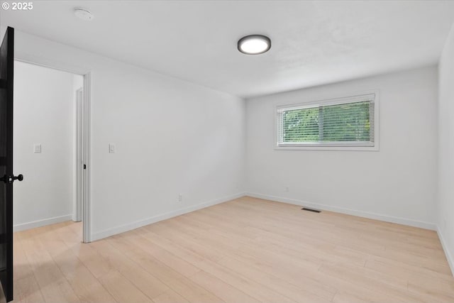 spare room featuring light wood-style floors and baseboards