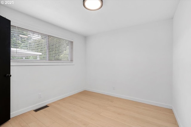 spare room with light wood-style flooring and baseboards