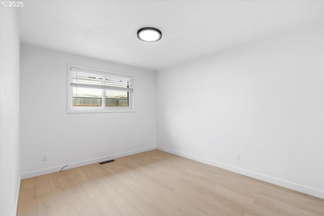unfurnished room with light wood-type flooring and baseboards