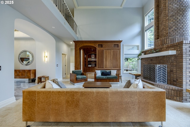 1564 Regency Dr, Eugene, OR 97401 - living area with a high ceiling, arched walkways, baseboards, and a brick fireplace