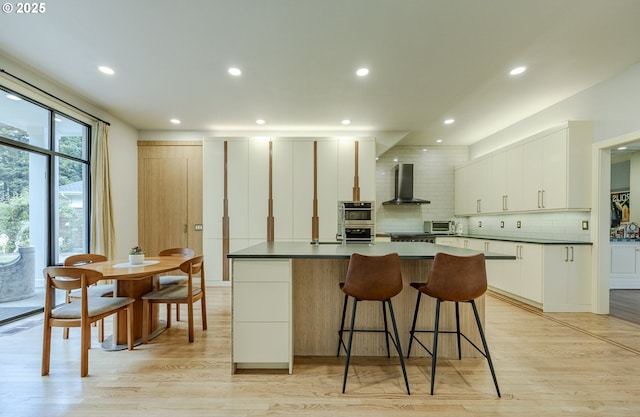 1564 Regency Dr, Eugene, OR 97401 - kitchen with wall chimney range hood, backsplash, a kitchen island, dark countertops, and recessed lighting