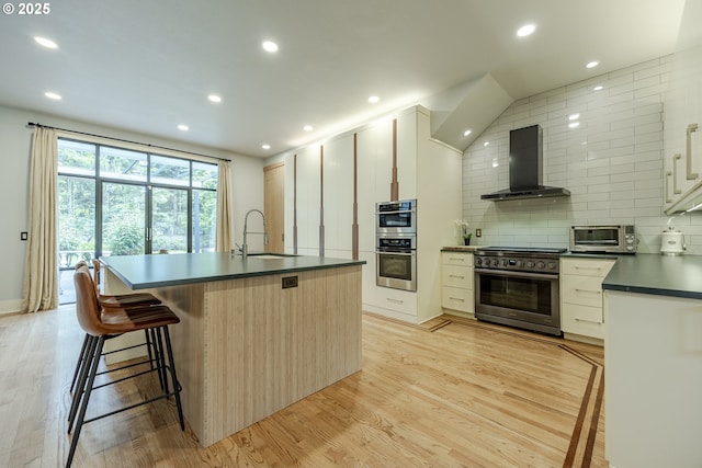 1564 Regency Dr, Eugene, OR 97401 - kitchen featuring wall chimney range hood, stainless steel appliances, a sink, dark countertops, and recessed lighting
