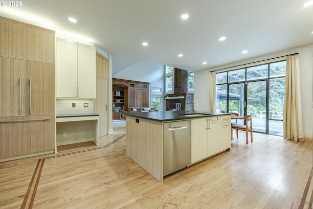 1564 Regency Dr, Eugene, OR 97401 - kitchen with stainless steel dishwasher, dark countertops, light wood finished floors, a kitchen island with sink, and recessed lighting