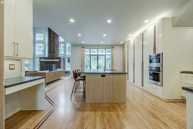 1564 Regency Dr, Eugene, OR 97401 - kitchen with dark countertops, plenty of natural light, light wood-style flooring, open floor plan, and recessed lighting