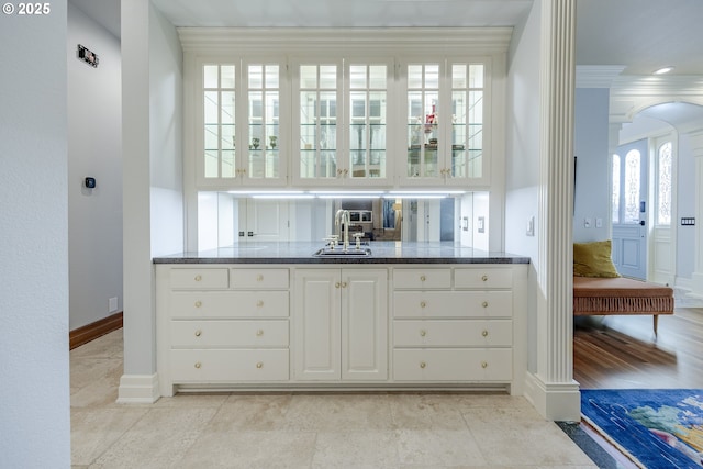 1564 Regency Dr, Eugene, OR 97401 - bar area featuring arched walkways, baseboards, ornamental molding, and a sink