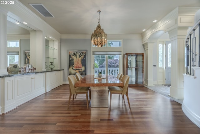 1564 Regency Dr, Eugene, OR 97401 - dining area featuring decorative columns, healthy amount of natural light, a chandelier, dark wood-style floors, and ornamental molding